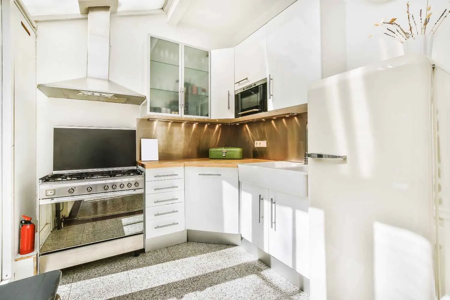 White kitchen with a gas range, wall oven and fridge